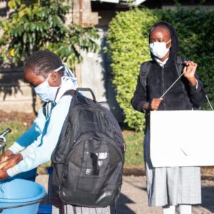 Pupils washing their hands, using non contact washing points, as they arrive.