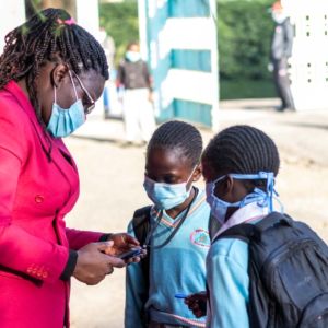 A teacher scanning the tags of pupils as they check in.