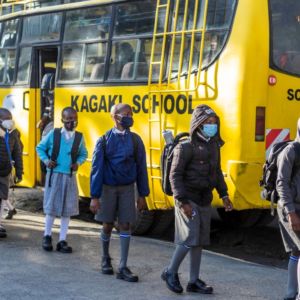 Pupils alighting from the bus, as they line up for check in.