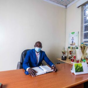 The Head-Teacher, Mr Cyrus Malanda poses for a photo in his office.